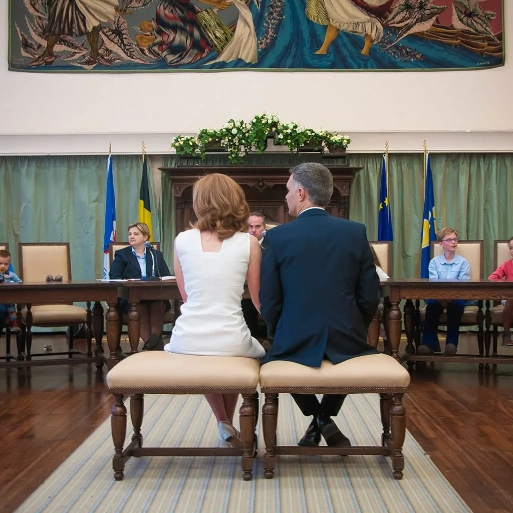 Mariés assis de dos devant l’officiante pendant une cérémonie civile