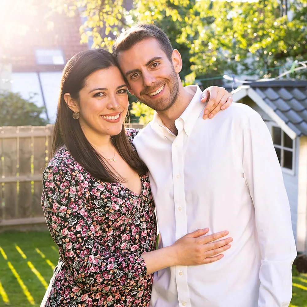 Portrait de couple en extérieur, rapprochés dans la lumière du jardin